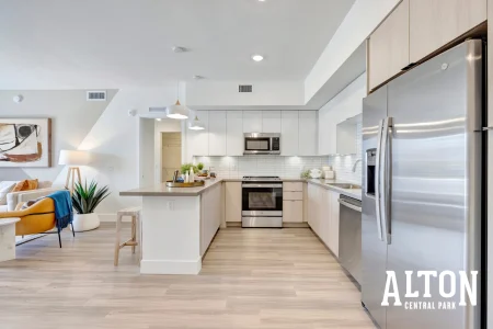 Modern apartment kitchen with stainless steel appliances and center island.