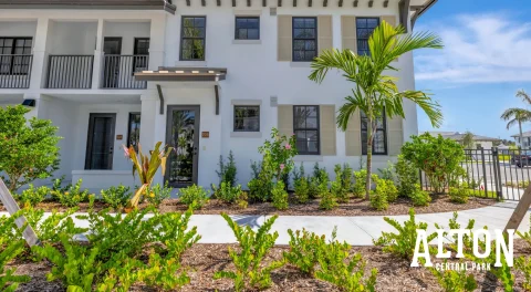 Two-story townhome exterior with palm trees and landscaped front area.