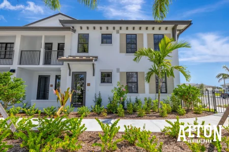 Two-story townhome exterior with palm trees and landscaped front area.