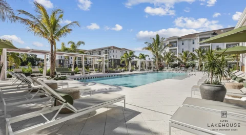 Resort-style apartment pool with palm trees and lounge chairs