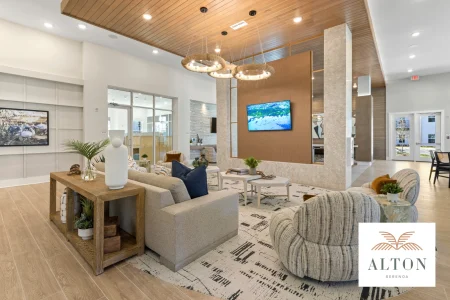 Modern clubhouse lounge with seating, wood ceiling, and mounted TV
