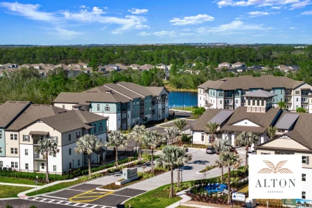 Aerial view of Alton Serenoa apartment community with palm trees and lake